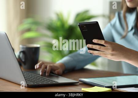 Close up portrait of businesswoman hands using multiple devices on a wooden table Stock Photo