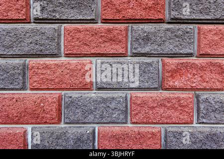 Close-up of a red and grey brick wall pattern. A detailed close-up image of a red and grey brick wall, showcasing the texture and pattern of the Stock Photo