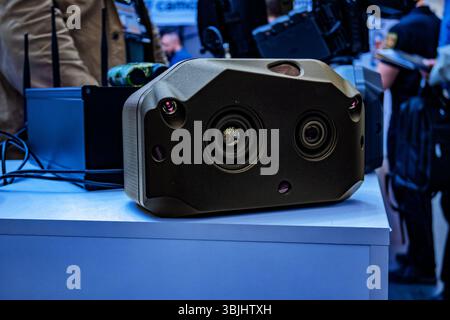Advanced surveillance camera technology showcased at event modern design and enhanced features for security applications with people blurred backgroun Stock Photo