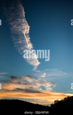 Wispy Vertical Cloud Formation at Sunset over Mountains in Brazil Stock Photo
