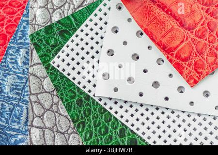 Colorful leather textures, perforated patterns in layered composition. Close-up of vibrant leather samples shows fashion material variety. Concept of Stock Photo
