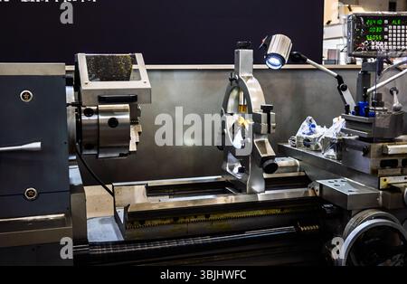 Detailed close-up of a metalworking lathe machine with steady rest and digital display in an industrial setting. Focus on precision machining and engi Stock Photo