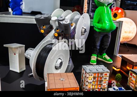 3D printing technology display with multi-spool filament holder and various printed objects like miniature buildings, figures, and art pieces Stock Photo