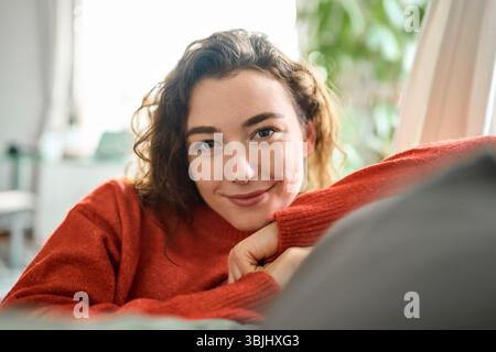 Young happy pretty woman relaxing sitting on couch at home. Portrait Stock Photo