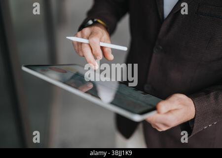 Businessman using a digital pen and tablet in an office setting Stock Photo