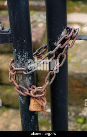 Riau, Indonesia - January 25, 2025: Close-up of rusty padlock on fence Stock Photo