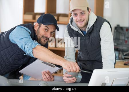 side view portrait of two new factory workers during training Stock Photo