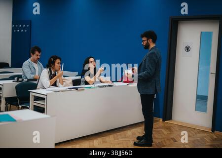 Professor assisting students during classroom session in university Stock Photo