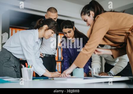 Collaborative business team engaged in a meeting around a project table Stock Photo