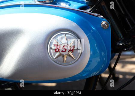 Close-up view of the BSA emblem on a vintage motorcycle fuel tank featuring blue and silver colors Stock Photo