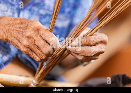 Close-up of skilled hands crafting coconut broom Stock Photo