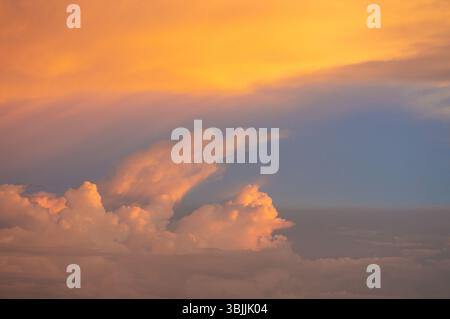Sunset clouds with golden and violet tones over a twilight sky Stock Photo