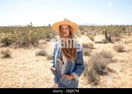 Bohemian dressed women with hat in desert Stock Photo