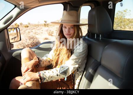 Bohemian dressed women with hat in pickup truck Stock Photo