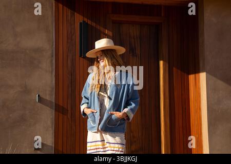 Woman outside in front of modern home Stock Photo