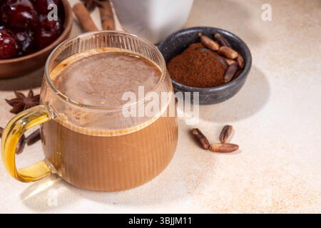 Healthy organic date seed coffee, coffee latte  cup, made with grated date seeds, with whole date fruits and seeds on beige background . Alternative c Stock Photo