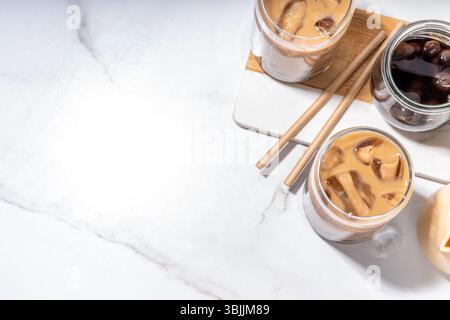 Iced tapioca coffee latte or boba pearl bubbles milk tea, asian trendy cold coffee drink with tapioca balls and crushed ice, on white marble backgroun Stock Photo