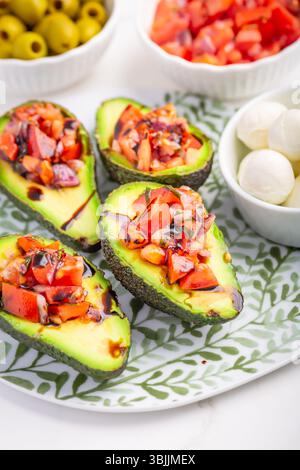 Vegan appetizers, avocados filled with bruschetta and balsamico vinaigrette Stock Photo