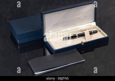 Branded pen in a box. Gift set. Selective focus. Office interior. Copy space Stock Photo