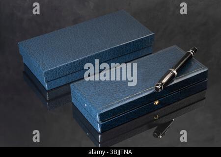 Branded pen in a box. Gift set. Selective focus. Office interior. Copy space Stock Photo