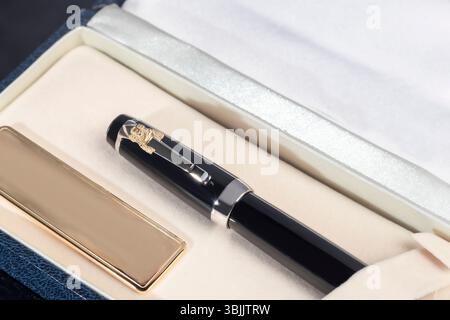 Branded pen in a box. Gift set. Selective focus. Office interior. Copy space Stock Photo