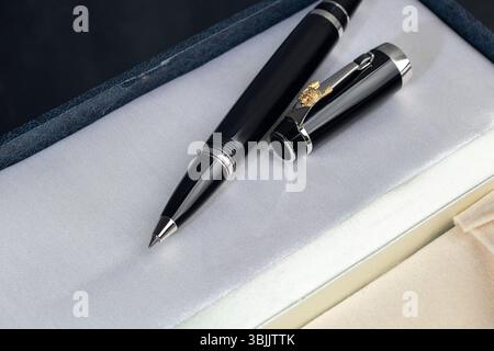 Branded pen in a box. Gift set. Selective focus. Office interior. Copy space Stock Photo