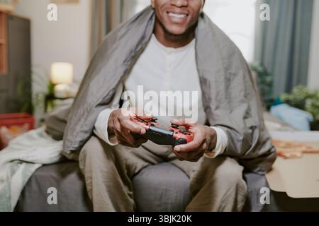 Portrait of Smiling Man Playing Video Game on Sofa Stock Photo
