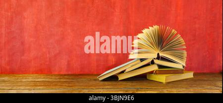 Heap of multicolored books on red grungy background Stock Photo