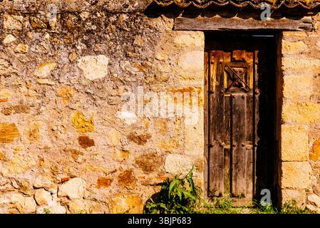 Stone facade with old wooden door. Pedraza, Segovia, Castilla y León, Spain, Europe Stock Photo