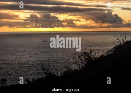 Golden sunset over the southern Atlantic Ocean as seen from a scenic draft along the mountainous coast of the Cape peninsula. Stock Photo