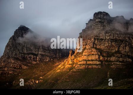 Mist flowing over and in between the majestic peaks of the Twelve Apostle Mountains, in South Africa, in the late afternoon Stock Photo