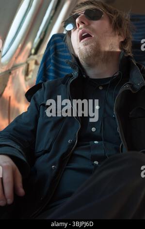 Portrait of a young man sleeping in a seat of an airplane Stock Photo