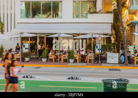 Outdoor diners at The Front Porch Cafe on Ocean Drive in Miami Beach during warm evening with palm shadows. Miami Beach. USA. Stock Photo