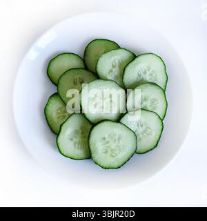 Sliced fresh cucumber in a white background. Salad ingredient. Healthy diet nutrition. Directly above. Stock Photo
