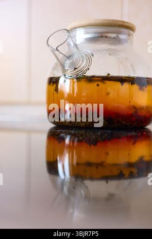 tea is brewed in a glass teapot, evaporation drops on the walls of the teapot Stock Photo