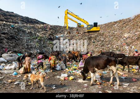 Big mixed rubbish dump and blue sky. Garbage Mountain. Garbage pile in trash dump or landfill abundance. Workers are working in waste dumping yard Stock Photo