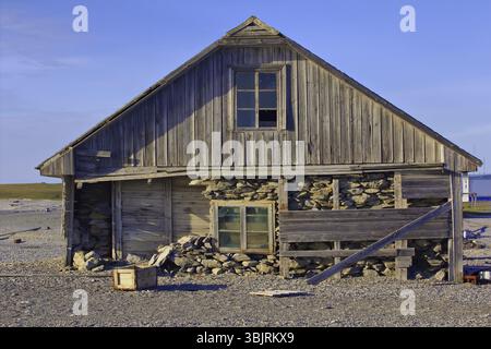 Three-layered house of old polar station on shore of Barents sea. Cape White Nose, Yugorsky Peninsula, Destroyed by hurricane and powerful storm Stock Photo