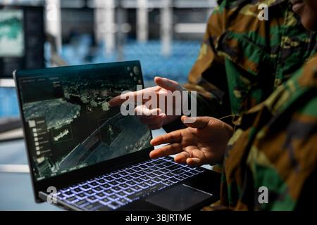 Close up of army experts in data center analyzing infrared surveillance feed on tactical interface. Military units operating real time satellite reconnaissance from secure server room Stock Photo