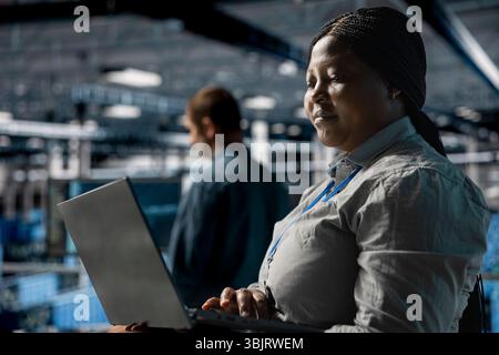 Teamworking data center programmers writing code for resource optimization using notebook. Server farm coworkers in data center refining algorithms for faster processing using laptop Stock Photo