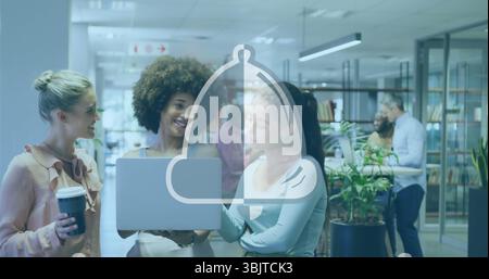 Collaborating three female colleagues working on laptop in open-plan office with coffee cups Stock Photo
