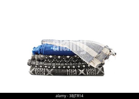 Stacked woven textiles in black, blue, and striped patterns Stock Photo