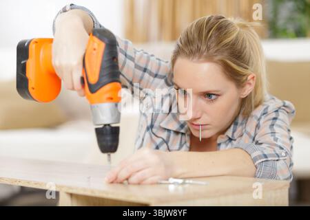 young woman using electric screwdriver Stock Photo