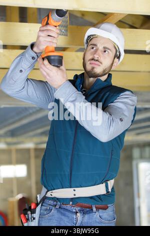 mature carpenter drilling wood Stock Photo