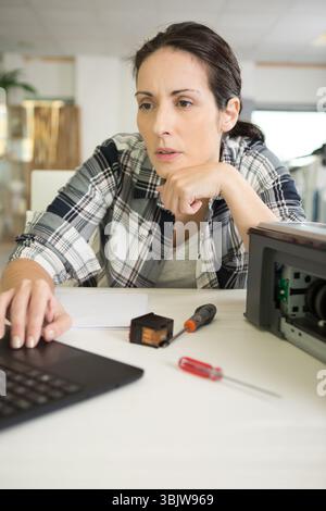 serious woman fixing a printer Stock Photo