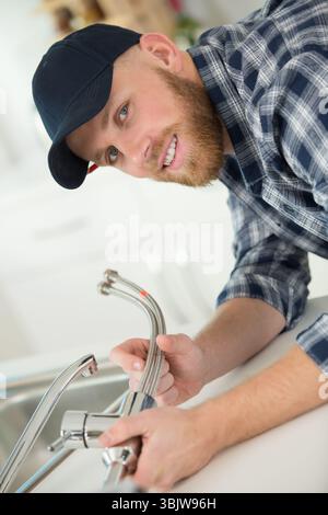 young professional plumber assembling sink pipe Stock Photo