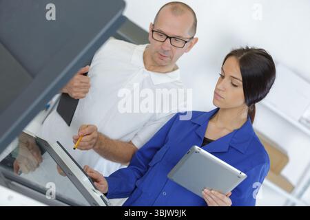 a woman fixing printer machine Stock Photo