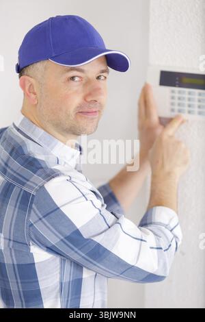 young male technician installing security system Stock Photo