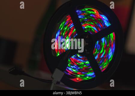 A striking image of a spool with vibrant multicolor LED lights glowing vividly against a dim background, showcasing their colorful and technological e Stock Photo