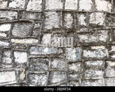 Old stone wall with rectangular granite blocks background, closeup view Stock Photo