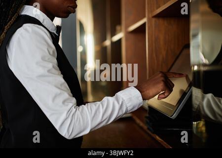 Young Adult Black Woman Using Touchscreen Register Working in Restaurant Stock Photo